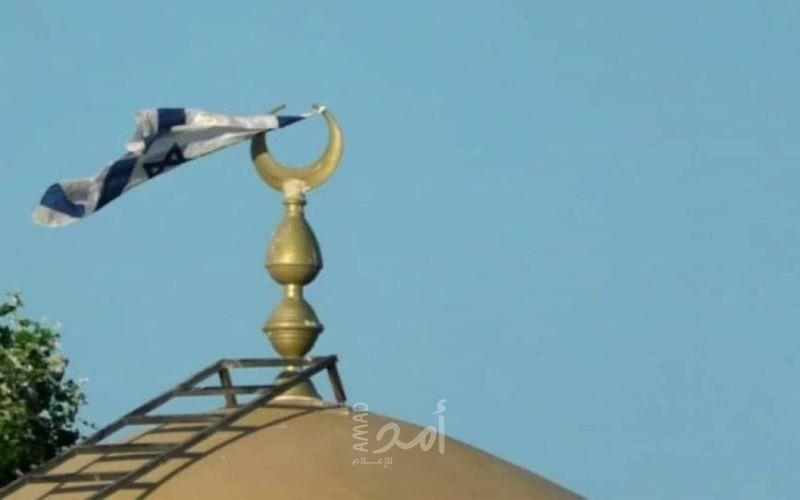 مستوطنون إرهابيون يرفعون أعلاماً إسرائيلية فوق مسجد كيسان شرق بيت لحم