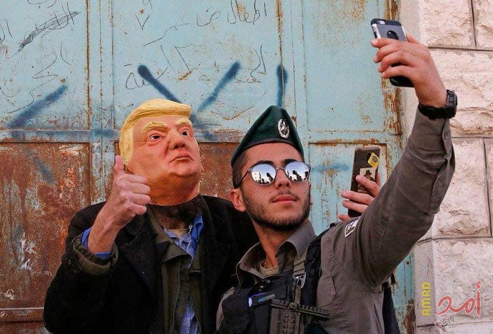 في تحدٍ سافر.. مستوطن يرتدي وجه ترامب يتجول في الخليل (صور)